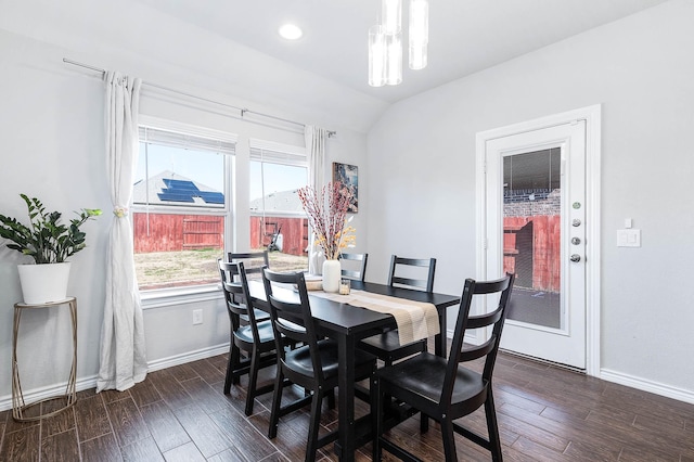 dining area with dark wood-type flooring and vaulted ceiling