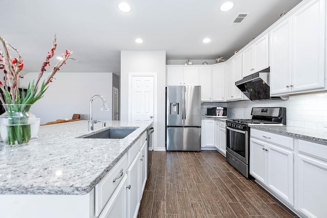 kitchen featuring sink, white cabinetry, appliances with stainless steel finishes, dark hardwood / wood-style floors, and light stone countertops