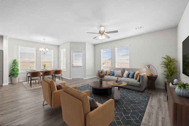 living room featuring hardwood / wood-style flooring and ceiling fan with notable chandelier