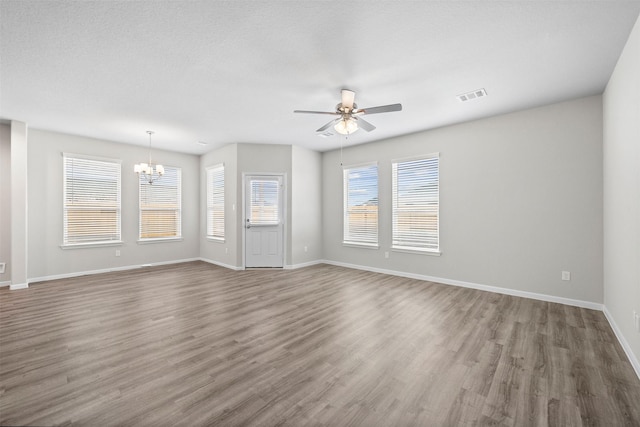 unfurnished living room featuring dark hardwood / wood-style flooring and ceiling fan with notable chandelier