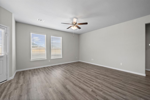 empty room featuring dark wood-type flooring and ceiling fan