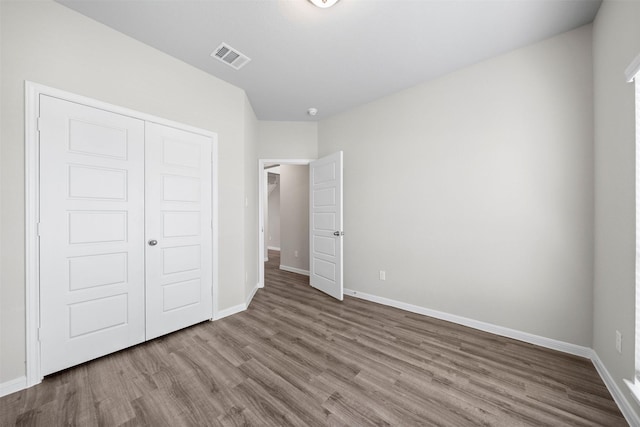 unfurnished bedroom featuring hardwood / wood-style flooring and a closet