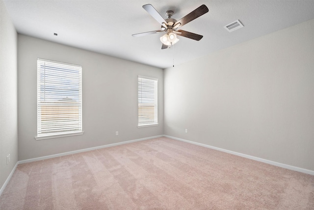 carpeted spare room featuring ceiling fan