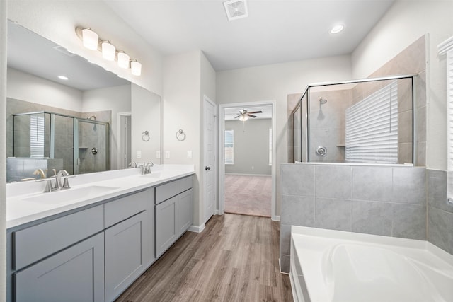 bathroom featuring independent shower and bath, vanity, wood-type flooring, and ceiling fan