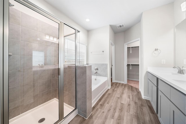 bathroom featuring vanity, wood-type flooring, and independent shower and bath