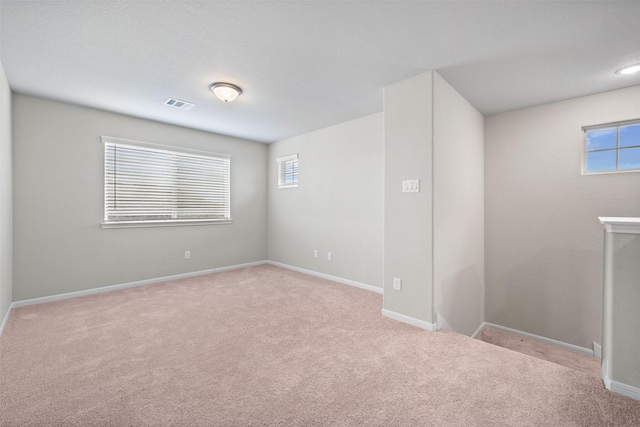 spare room featuring a healthy amount of sunlight and light carpet