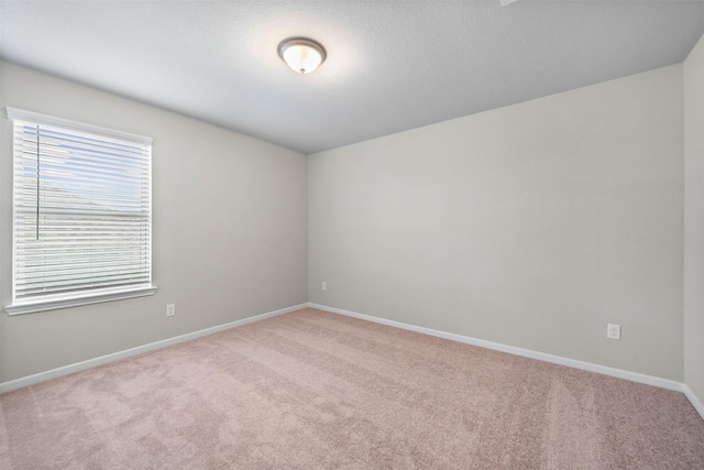 spare room featuring light colored carpet