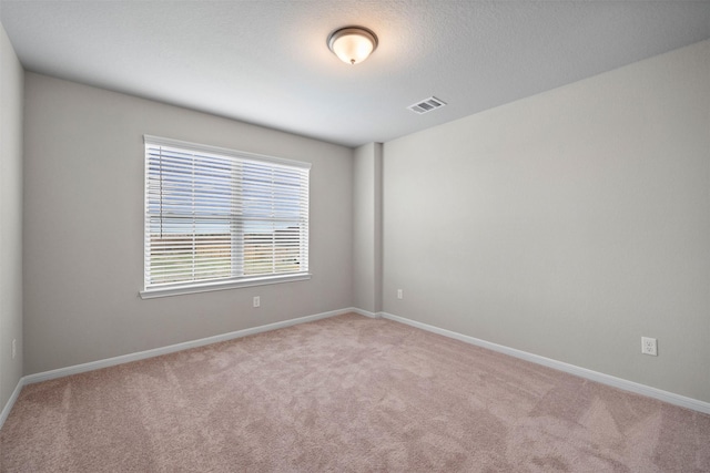 carpeted empty room with a textured ceiling