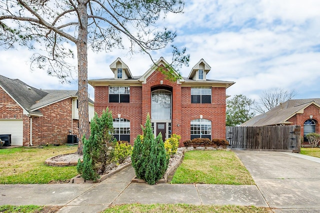 view of front of house with central AC and a front yard