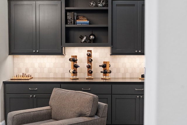 bar with gray cabinetry and backsplash