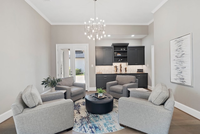 living room featuring an inviting chandelier, ornamental molding, and dark hardwood / wood-style floors