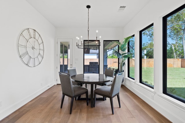 dining room featuring wood-type flooring and a healthy amount of sunlight