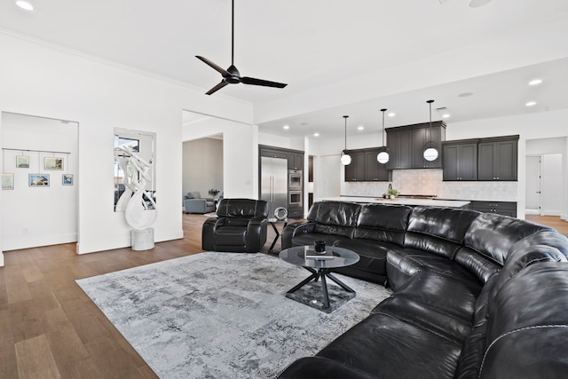 living room with ornamental molding, dark hardwood / wood-style floors, and ceiling fan