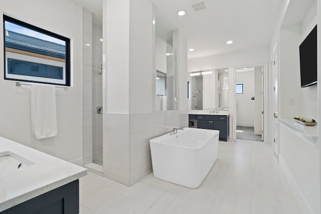 bathroom featuring vanity and separate shower and tub