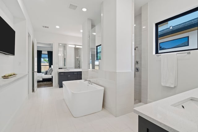 bathroom with vanity and independent shower and bath