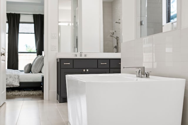 bathroom featuring tile patterned flooring, vanity, separate shower and tub, and tile walls