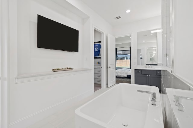 bathroom with vanity and a tub