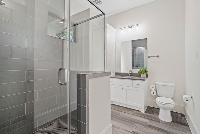 bathroom featuring walk in shower, vanity, and toilet