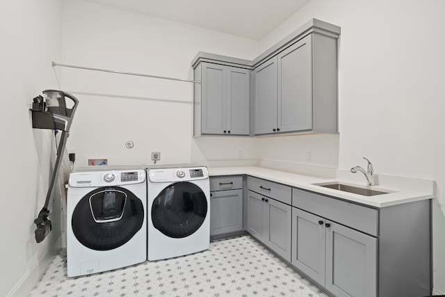 laundry room with cabinets, washer and dryer, and sink