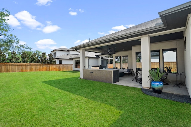 view of yard with exterior kitchen and a patio