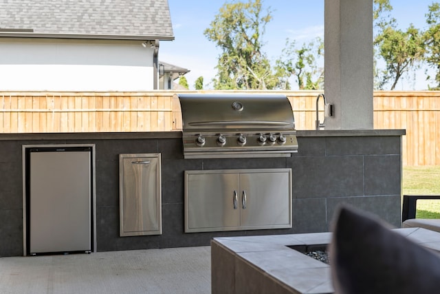 view of patio with area for grilling and a grill