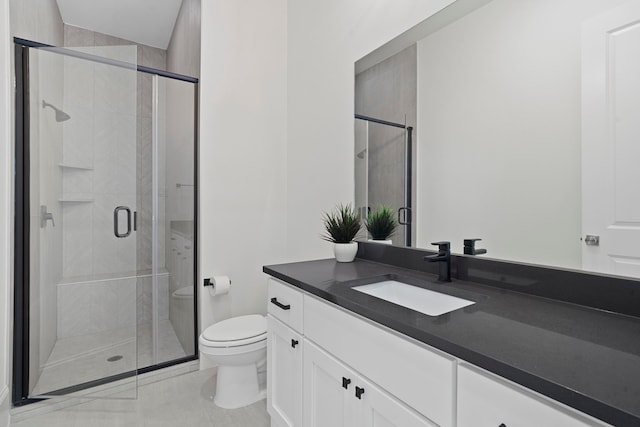 bathroom featuring a shower with door, vanity, and toilet