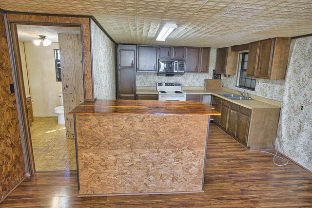 kitchen with electric stove, sink, dark hardwood / wood-style floors, a center island, and dark brown cabinetry