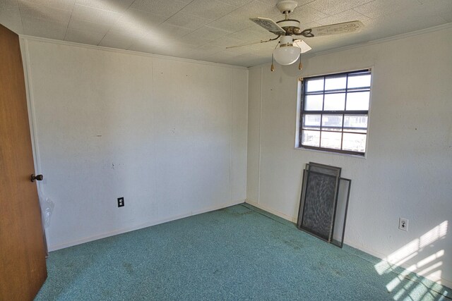 empty room featuring crown molding, carpet, and ceiling fan