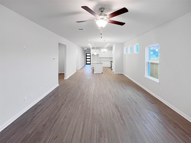 unfurnished living room with dark wood-type flooring and ceiling fan