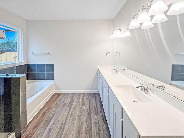 bathroom with vanity, a bath, and hardwood / wood-style flooring