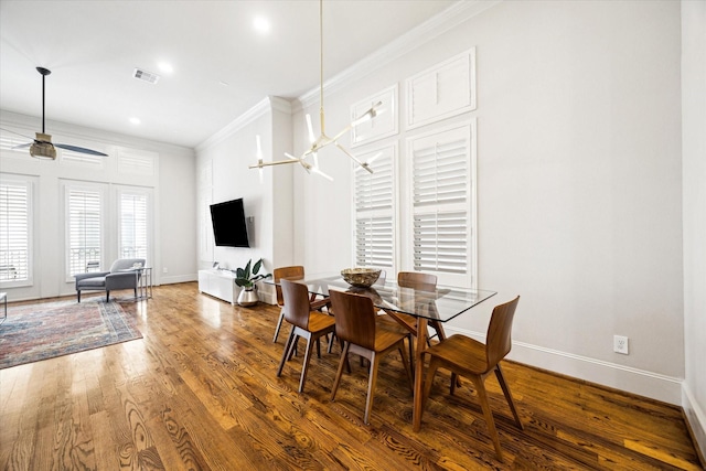 dining room with visible vents, baseboards, ceiling fan, wood finished floors, and crown molding