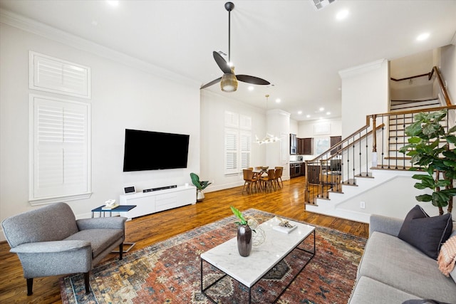 living area featuring crown molding, stairway, wood finished floors, and recessed lighting