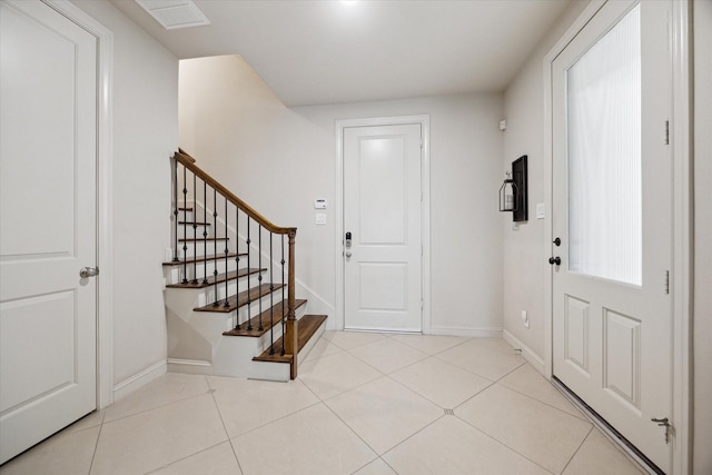 entrance foyer featuring tile patterned flooring, baseboards, and stairs