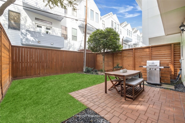 view of patio featuring outdoor dining space, a fenced backyard, and area for grilling