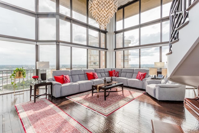 living room with a towering ceiling, wood-type flooring, and a wall of windows