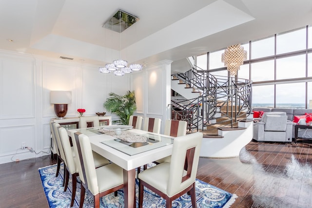 dining room featuring a tray ceiling, dark wood-type flooring, and a chandelier