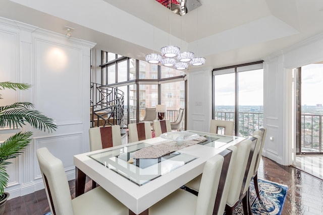 dining room with a raised ceiling, a notable chandelier, and dark hardwood / wood-style flooring