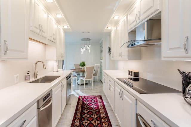 kitchen with wall chimney range hood, white cabinetry, sink, and black electric stovetop