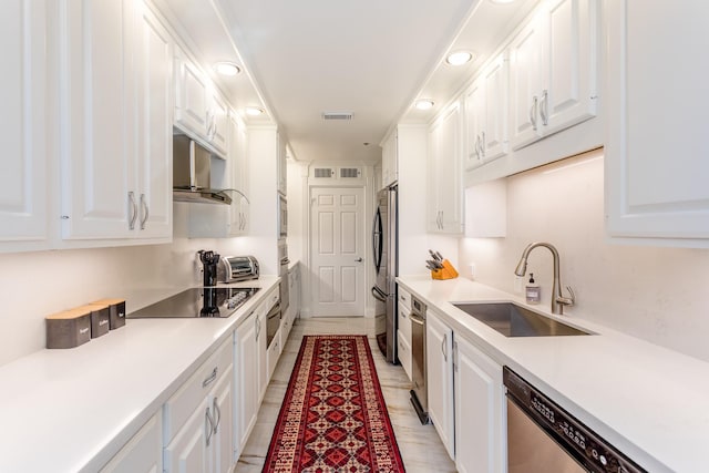 kitchen with appliances with stainless steel finishes, sink, exhaust hood, and white cabinets