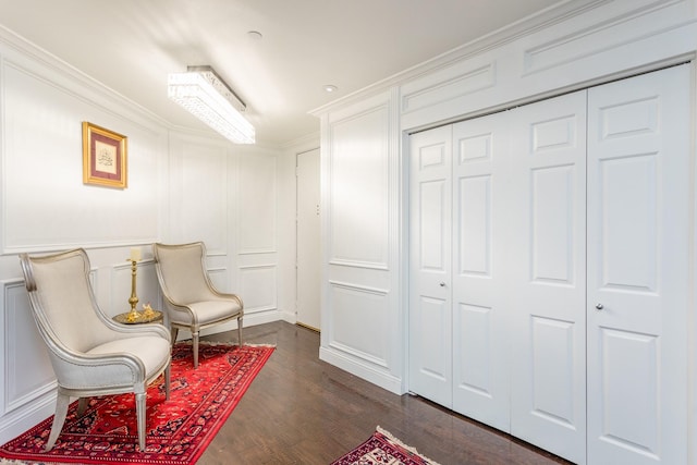 living area featuring dark wood-type flooring and crown molding