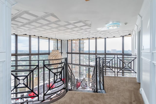 hallway with floor to ceiling windows and carpet flooring