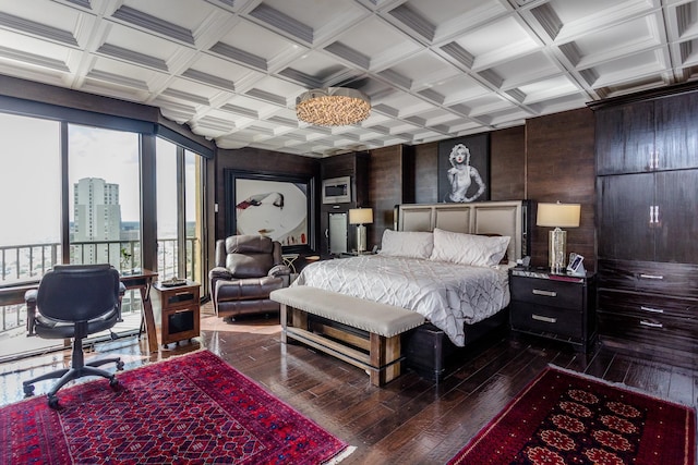 bedroom featuring coffered ceiling, dark hardwood / wood-style flooring, access to exterior, and beamed ceiling