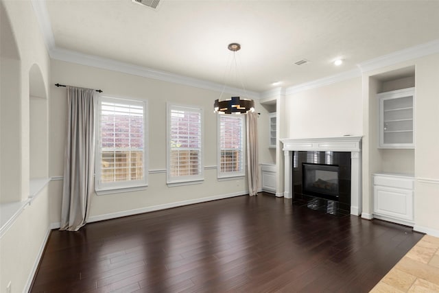 unfurnished living room featuring dark hardwood / wood-style flooring, crown molding, a fireplace, and a chandelier