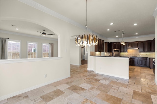 kitchen featuring tasteful backsplash, crown molding, dark brown cabinets, appliances with stainless steel finishes, and ceiling fan with notable chandelier