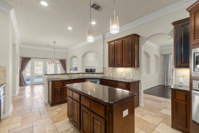 kitchen featuring pendant lighting, sink, kitchen peninsula, and a kitchen island