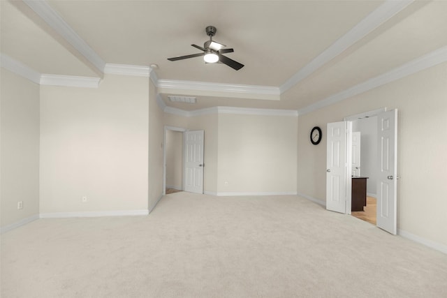 carpeted empty room featuring ornamental molding, ceiling fan, and a tray ceiling