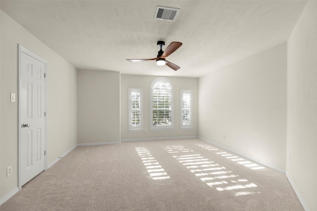 empty room featuring light carpet, a textured ceiling, and ceiling fan