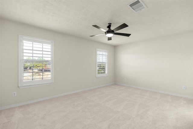 carpeted spare room with ceiling fan and a textured ceiling