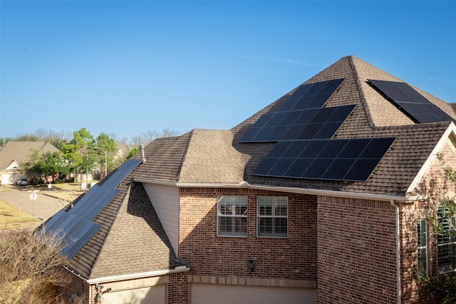 exterior space with a garage and solar panels