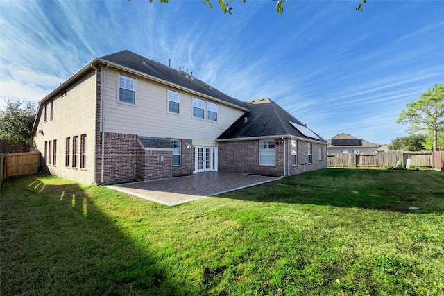 rear view of property with a yard and a patio area